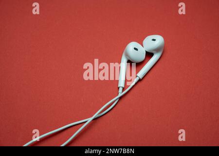 IPhone Apple Ohrhörer, AirPods weiße Ohrhörer, Kopfhörer zum Anhören von Musik und Podcasts. Isolierter gelber Hintergrund. Budapest, Ungarn - Februar Stockfoto