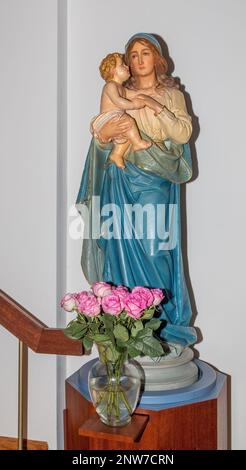 Jungfrau Maria hält das Jesuskind mit rosa Rosen zu Ehren des Monats des Heiligen Rosenkranzes in St. Joseph's Catholic Church, Taylors Falls, Minnesota Stockfoto