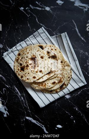 Gebratenes Pita-Brot in der Pfanne auf dunklem Hintergrund. Draufsicht Stockfoto
