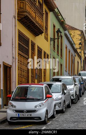 Eine Reihe von Autos, die entlang der farbenfrohen Calle Tomás Pérez in La Orotava auf Teneriffa geparkt werden Stockfoto