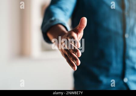 Lassen Sie uns diesen Deal besiegeln. Ausgeschnittene Aufnahme eines nicht erkennbaren Geschäftsmannes, der allein in seinem Home Office steht und seine Hand ausstreckte, um sich zu bewegen. Stockfoto