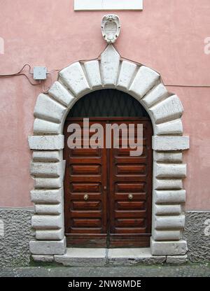 Alte Holztür mit Familienwappen. Eine der vielen interessanten alten Türen im historischen Italien Stockfoto