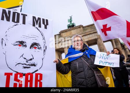 Berlin, Deutschland, 27-2-22. Eine Frau mit einem großen Putin-Schild demonstriert, die Ukraine bei einer Friedensdemonstration nahe dem Brandenburger Tor zu unterstützen Stockfoto