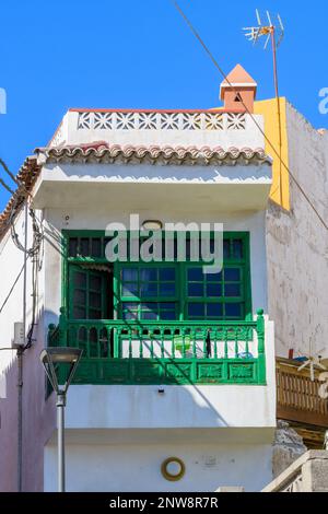 Ein hellgrüner Holzbalkon auf der Seite eines weiß getünchten Gebäudes in Candelaria, Teneriffa. Stockfoto