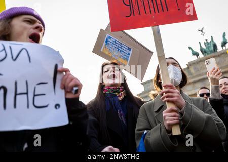 02-27-22 Eine Gruppe junger Demonstranten mit provisorischen Bannern schreit bei der Berliner Friedensdemonstration nahe dem Brandenburger Tor Antikriegsgesänge, um die Ukraine zu unterstützen Stockfoto