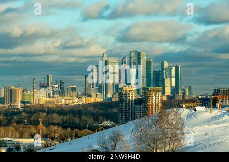 Atemberaubendes Panorama von Winter-Moskau bei Sonnenuntergang von der Krylatskie Holmy (Krylatskoe Hills) und dem Moskauer Stadtviertel mit Wolkenkratzern und einigen Gebäuden Stockfoto