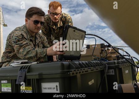 USA Marinekorps Lance CPL, Clayton Fordham, Left, und Lance CPL, Michael Watson, rechts, beide Geheimdienste, Überwachung, Und Aufklärungssysteme Ingenieure mit dem 3. Intelligence Battalion, III Marine Expeditionary Force Information Group, stellen die Kommunikation mit einem High Bandwidth Special Intelligence-Palletized Terminal Satellite her, um die Übung Azure Dragon in Camp Courtney, Okinawa, Japan, vorzubereiten, 9. Januar 2023. Azure Dragon ist eine von III MEF durchgeführte Übung, um Kriegsspielszenarien zu besprechen und zu planen. III MIG fungiert als Vorhut der III MEF und arbeitet im Indo-Paci Stockfoto