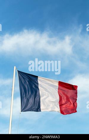 Die französische blaue, weiße und rote Flagge wird durch starken Wind aufgewühlt. Das Tricolor National Stockfoto