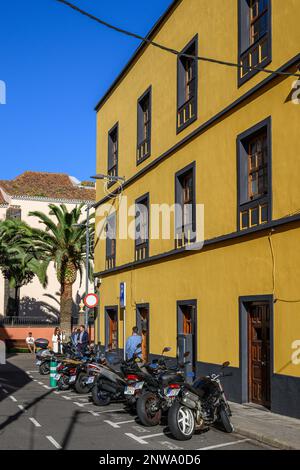 Eine Reihe von Motorrädern parkt bei einem hellgelben Gebäude in Antigua Calle San Fructuoso, La Laguna, Teneriffa Stockfoto