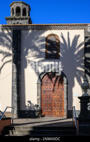 Die Nachmittagssonne wirft Schatten von Palmen auf die Mauer der Iglesia de la Concepción von La Laguna auf der Plaza Doctor Olivera. Stockfoto