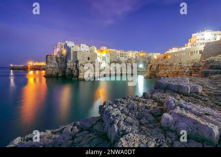 Fantastische Nachtszene am Golf von Cala Paura mit Bastione di Santo Stefano im Dorf auf den Felsen Polignano A Mare, Apulia, Italien, Provinz Bari. Stockfoto