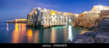 Fantastische Nachtszene am Golf von Cala Paura mit Bastione di Santo Stefano im Dorf auf den Felsen Polignano A Mare, Apulia, Italien, Provinz Bari. Stockfoto