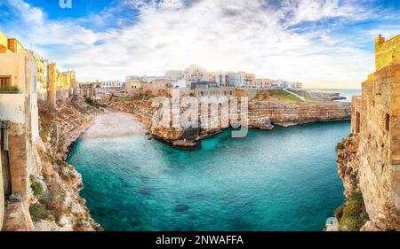 Atemberaubender Sonnenuntergang am Golf von Cala Paura mit Bastione di Santo Stefano und Lama Monachile Beach im Hintergrund. Polignano a Mare, Apulien, Italien, Provinz Stockfoto