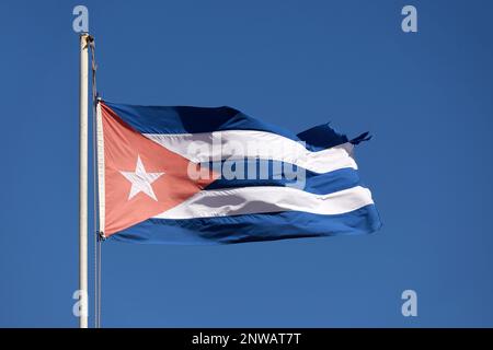 Die Nationalflagge Kubas winkt gegen den blauen Himmel Stockfoto