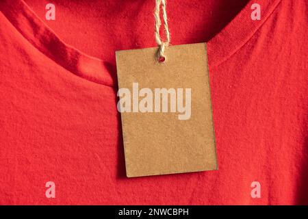 Karton, Verpackung, lässig, Kleidung, Branding, Shopping, braunes Papier Preisschild wiegt auf Kleidung auf einem Rack auf einem Kleiderbügel im Verkaufsbereich, blank pri Stockfoto