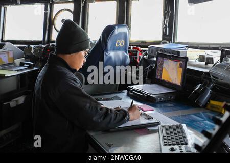 230202-N-JO162-1028 BAB AL-MANDEB (2. Februar 2023) Quartermaster Seaman Russel Raagas steht Wache im Pilothaus der Flugkörperzerstörerin USS Truxtun (DDG 103) während einer Durchreise der Bab Al-Mandeb am 2. Februar 2023. Truxtun wird im US-Flottengebiet 5. eingesetzt, um die maritime Sicherheit und Stabilität im Nahen Osten zu gewährleisten. Stockfoto