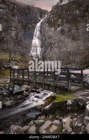 Die hölzerne Brücke an den Aber Falls, einem riesigen Wasserfall von etwa 37m m in der Nähe des Dorfes Abergwyngregyn in Nordwestwales, Großbritannien Stockfoto