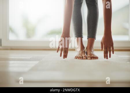 Yoga kann immer an die Bedürfnisse der Menschen angepasst werden. Eine kurze Aufnahme einer jungen Frau, die zu Hause Yoga praktiziert. Stockfoto