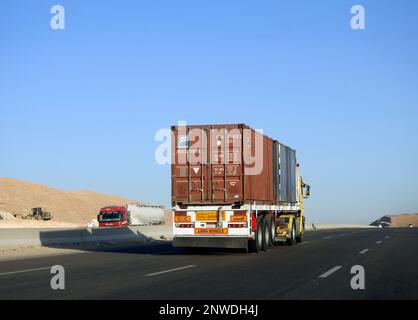 Gizeh, Ägypten, Januar 26 2023: Großer Tieflader-Lkw mit einem Stahlcontainer auf einer Autobahn in Ägypten, Versand- und Lieferservice-con Stockfoto