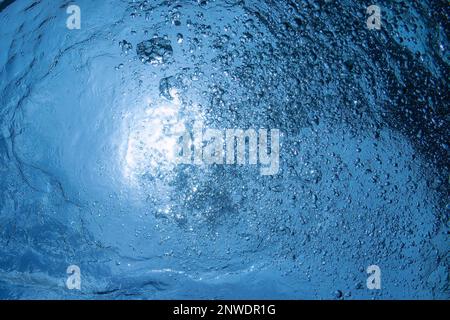 Nahaufnahme von vielen schönen Unterwasser-Luftblasen steigen durch blaues Meerwasser von atmenden aufsteigenden Fahrer, Nahaufnahme Foto. Sonnenlicht Stockfoto