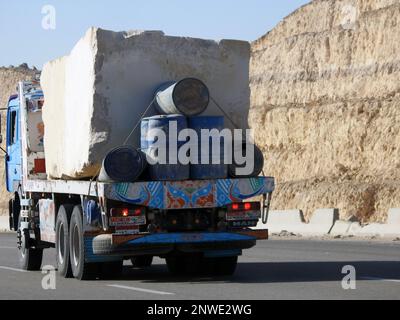 Gizeh, Ägypten, Januar 26 2023: Ein großer Lkw beladen mit großen Steinblöcken, Kalkstein, Steinen aus Steinbrüchen in Bergen, die auf einem transportiert werden Stockfoto