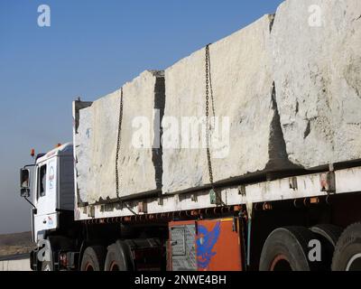 Gizeh, Ägypten, Januar 26 2023: Ein großer Lkw beladen mit großen Steinblöcken, Kalkstein, Steinen aus Steinbrüchen in Bergen, die auf einem transportiert werden Stockfoto