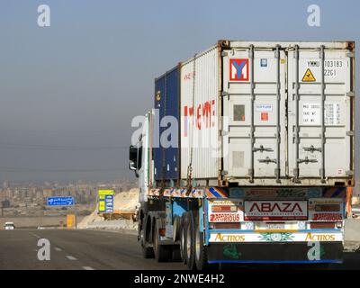 Gizeh, Ägypten, Januar 26 2023: Großer Tieflader-Lkw mit einem Stahlcontainer auf einer Autobahn in Ägypten, Versand- und Lieferservice-con Stockfoto