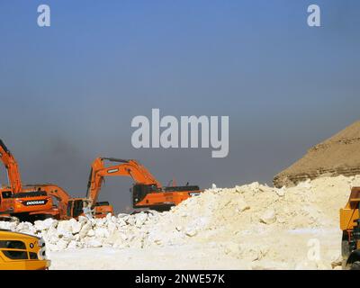 Gizeh, Ägypten, Januar 26 2023: Steinbrüche in Bergen und Wüsten in Ägypten, die Steine, Kalkstein und Felsen mit Baggern abbauen und auf Fla beladen Stockfoto