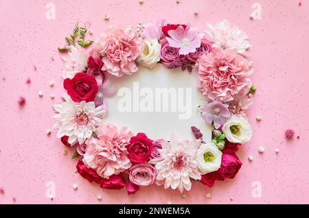 Rosafarbener Blumenrahmen mit weißem Hintergrund. Flach liegend, Draufsicht Stockfoto