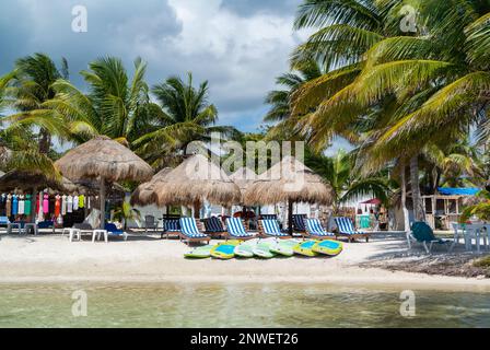 Mahahual, Quintana Roo, Mexiko, Beach Club mit langen Stühlen und Sonnenschirmen mit Palmen am Mahahual Beach Stockfoto