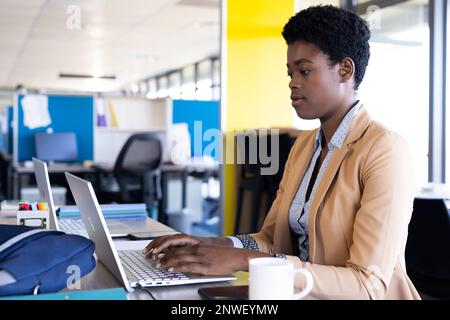 afroamerikanische Geschäftsfrau, die im Büro ein Notebook benutzt. Arbeit im Büro, Geschäft, Finanzen und Unternehmenskonzept. Stockfoto