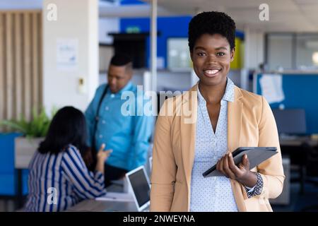 Porträt einer afroamerikanischen Geschäftsfrau, die in die Kamera schaut und im Büro lächelt. Arbeit im Büro, Geschäft, Finanzen und Unternehmenskonzept. Stockfoto