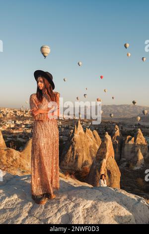 Ein wunderschönes Mädchen steht und schaut sich Ballons in Kappadokien an Stockfoto