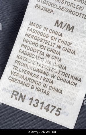 „Made in China“-Kleidungsetikett in mehreren Sprachen. Für die chinesische Textilindustrie, Outsourcing nach China, Sprachübersetzungen, Sprachkenntnisse. Stockfoto