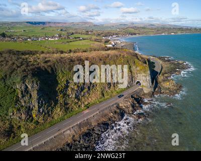 Luftaufnahmen von verschiedenen Orten in und um Larne, County Antrim, Nordirland. Auf diesem Foto ist dies die Küstenstraße A2 am Damm, die durch den schwarzen Arch-Tunnel führt, während Sie Larne weiter in Richtung Norden verlassen. Stockfoto