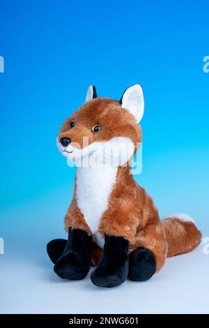 Red Fox Plüschtier auf einem nahtlosen blau-weißen Hintergrund. Stockfoto