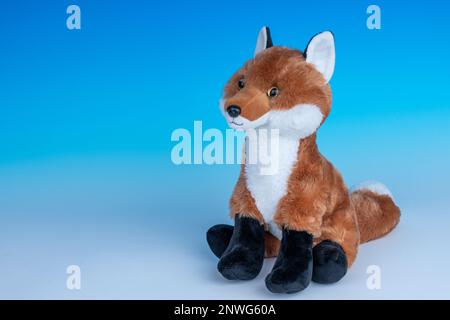 Red Fox Plüschtier auf einem nahtlosen blau-weißen Hintergrund. Stockfoto