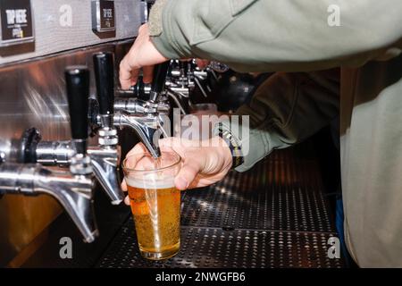 Ein Gast des Cherry Point Public House am Eröffnungsabend nutzt die Selbstbedienungs-Bar an der Marine Corps Air Station Cherry Point, North Carolina, 26. Januar 2023. Marine Corps Community Services entwarf das Public House, um eine Community auf der Basis mit einer modernen, vielseitigen Umgebung zu bieten, in der das Personal Genossen genießen und aufbauen kann. Stockfoto