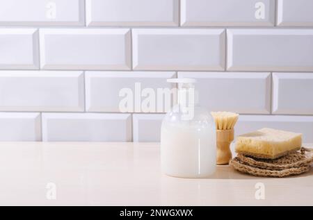 Flüssigreiniger, Naturschwämme Bürste zum Abwaschen von Geschirr und Küchenutensilien auf dem Küchentisch Stockfoto