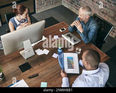 Das Wachstum des Unternehmens Tag für Tag zu beobachten. Aufnahme einer Gruppe von Leuten, die in einem Büro arbeiten. Stockfoto