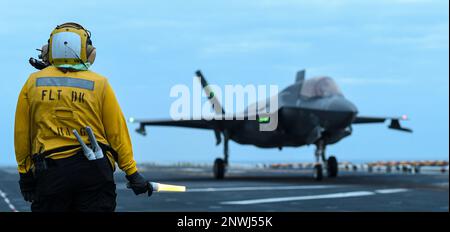 PHILIPPINE SEA (14. Januar 2023) Aviation Boatswain’s Mate (Handling) Airman Cassandra Flores, aus Bakersfield, Kalifornien, dem nach vorn eingesetzten Amphibienflugzeug USS America (LHA 6) zugewiesen, Beobachtet ein Flugzeug der Baureihe F-35B Lightning II vom Marine Fighter Attack Squadron (VMFA) 242 vor dem Abflug vom Cockpit des Schiffes während der Fahrt in der Philippinischen See, Januar 14. America, das führende Schiff der America Amphibious Ready Group, ist im 7.-Flottenbereich tätig. 7. Fleet sind die USA Marineflotte mit der größten Anzahl von Flotten, die regelmäßig interagiert und operiert Stockfoto