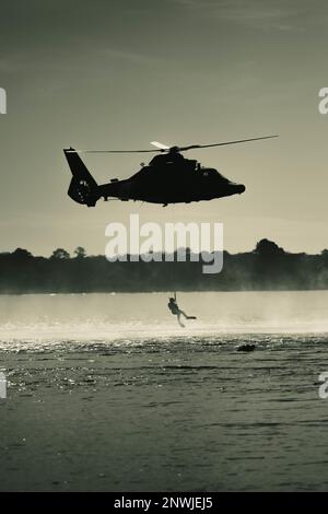 EIN US-AMERIKANISCHER Coast Guard Eurocopter MH-65 Dolphin Helicopter von Air Station Savannah schwebt während des Hubschraubertrainings im Hafen von Charleston, South Carolina, 5. Januar 2023. Die Besatzung trainiert routinemäßig für Hebevorrichtungen, falls eine medizinische Evakuierung in der Praxis erforderlich ist. Stockfoto