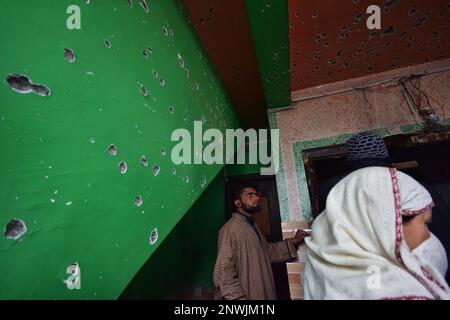 Srinagar, Indien. 28. Februar 2023. Menschen, die sich ein beschädigtes Wohnhaus ansehen, in dem zwei lokale Kämpfer in der Gegend Padgham Pora im Pulwama-Bezirk von Südkaschmir getötet wurden, führten Kaschmir am 28. Februar 2023 unter indischer Regierung aus. Zwei Kämpfer wurden bei einer nächtlichen Begegnung mit indischen Streitkräften getötet, 2 Wohnhäuser und eine Moschee wurden ebenfalls beschädigt. (Foto von Mubashir Hassan/Pacific Press) Kredit: Pacific Press Media Production Corp./Alamy Live News Stockfoto