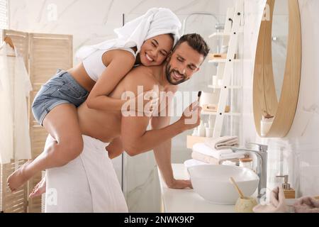 Ein reizendes Paar, das Spaß beim Zähneputzen im Badezimmer hat Stockfoto