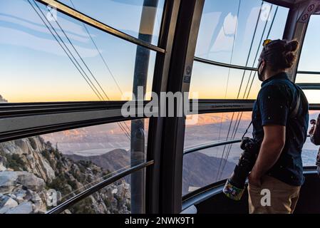 Mann, Tourist, der mit der Palm Spring Seilbahn zum San Jacinto Peak Park in Kalifornien fährt, im Herbst bei Sonnenuntergang. Stockfoto