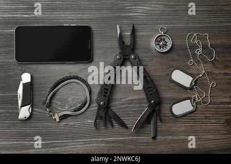 Flache Verlegung mit kompaktem tragbarem Multitool und Zubehör auf Holztisch Stockfoto