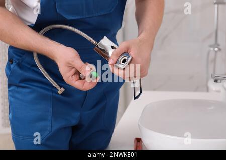 Professioneller Klempner repariert Wasserhahn im Badezimmer, Nahaufnahme Stockfoto