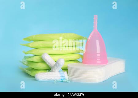 Menstruationseinlagen und andere Hygieneprodukte auf hellblauem Hintergrund Stockfoto