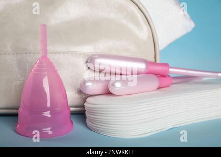 Beutel mit Menstruationseinlagen und anderen Hygieneprodukten auf hellblauem Hintergrund, Nahaufnahme Stockfoto