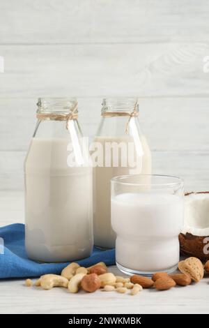 Verschiedene Nussmilch auf weißem Holztisch Stockfoto